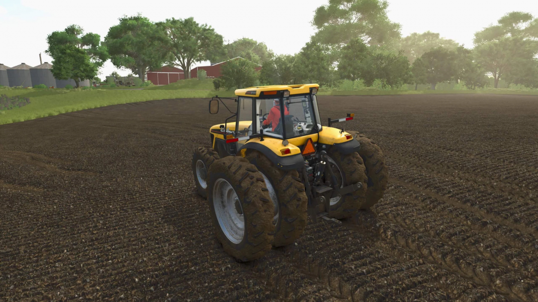 Farming Simulator 25 mod: A yellow AGCO Rowcrop Tractor working on tilled soil in a farm field with trees and farm buildings in the background.