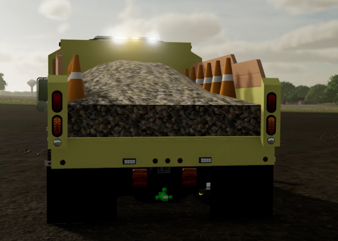 Farming Simulator 22 mod: Green dump truck loaded with gravel, dirt, and traffic cones, used for construction and farming tasks.