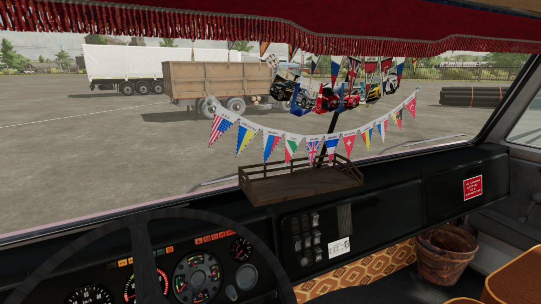 Interior of a truck in Farming Simulator 22 with colorful flags, a wooden tray, and a sticker on the dashboard, showcasing a KamAZ 5320 mod.