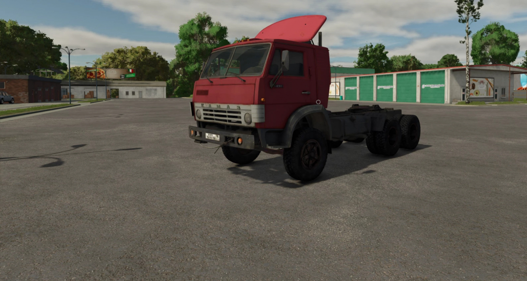 Farming Simulator 25 mod: Red KamAZ 5410 truck without trailer, in a parking lot with trees and buildings in the background.