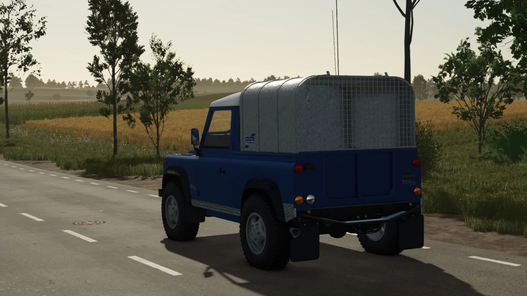 Farming Simulator 25 mod: Land Rover Defender v1.0.0.0 on a rural road, showcasing a blue vehicle with a cargo area, part of FS25 mods.