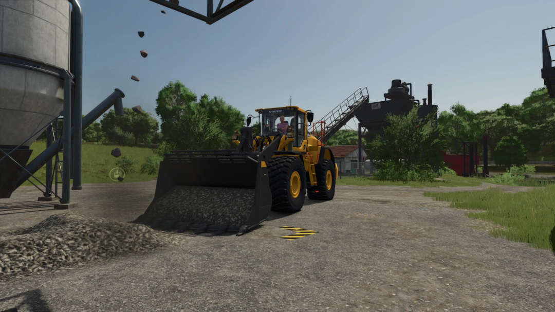 Farming Simulator 25 mod: yellow wheel loader operating on a construction site with gravel pile and industrial background.