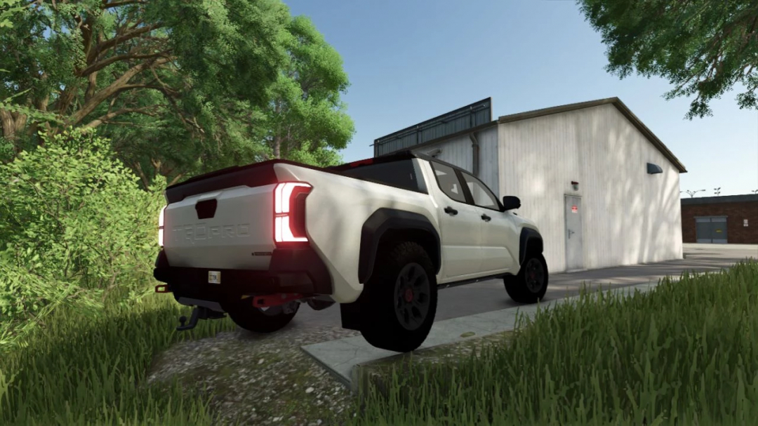 Farming Simulator 25 mod: Toyota Tacoma TRD PRO v1.0.0.0 parked near a building with trees in the background.