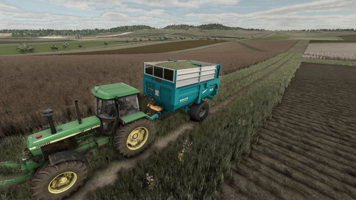 fs25-mods,  FS25 mod: Green John Deere tractor with attached blue Rolland TurboClassic 9-17 trailer on a farm field.