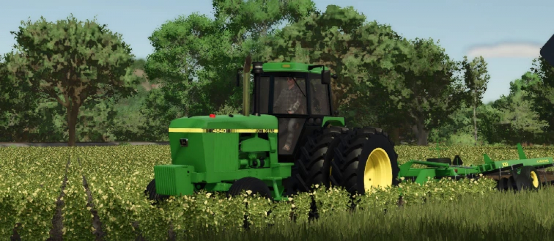 Farming Simulator 25 mod: John Deere 4840 tractor working in a green field surrounded by trees.
