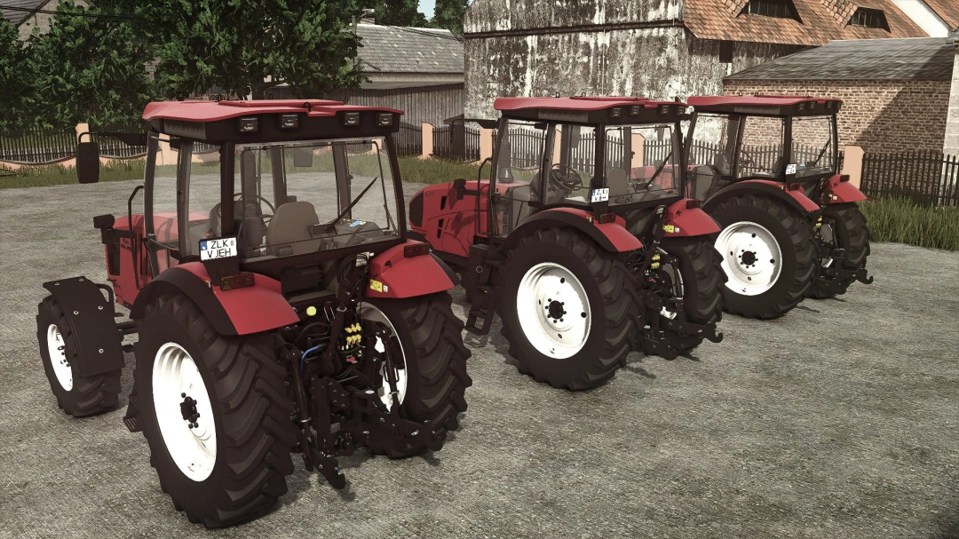 Three red tractors with large tires, part of FS25 mods, parked on a gravel surface in Farming Simulator 25.