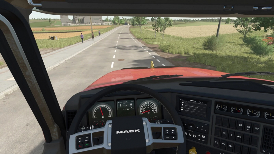 Inside view of a Mack Pinnacle 64R truck from Farming Simulator 25, showing the dashboard and road ahead with fields and trees.