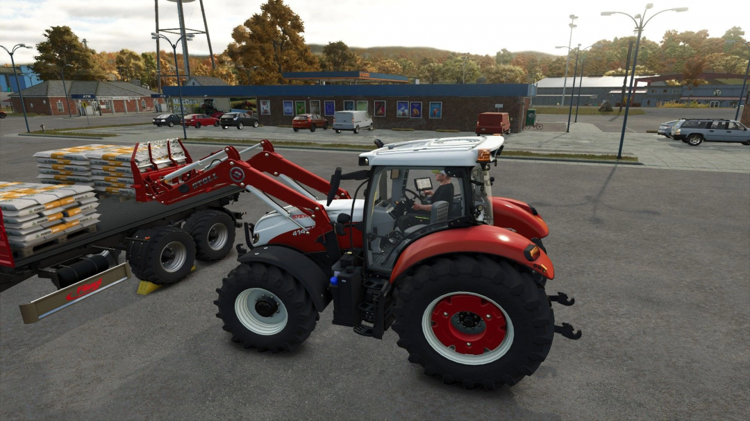 Farming Simulator 25 mod: Red and white Steyr tractor with front loader carrying pallets of fertilizer in a parking lot.