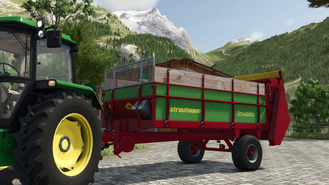 Farming Simulator 25 mod featuring a green and red Strautmann Streublitz BE 5 manure spreader Trailer attached to a tractor with mountain scenery in the background.