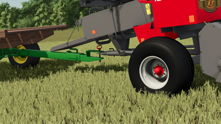 fs25-mods, Close-up of a farming trailer with a Massey Ferguson MF 1840 Baler mod in Farming Simulator 25, on a grassy field.