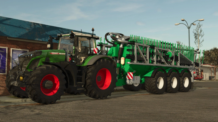 fs25-mods,  Farming Simulator 25 mod: green Fendt tractor with attached Samson Agro PGII Pack fertilizer spreader, large and detailed, in a farm yard.