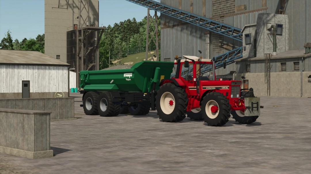 Farming Simulator 25 mod: Red International 1255 XL tractor with green Krampe dump trailer at a farm facility.