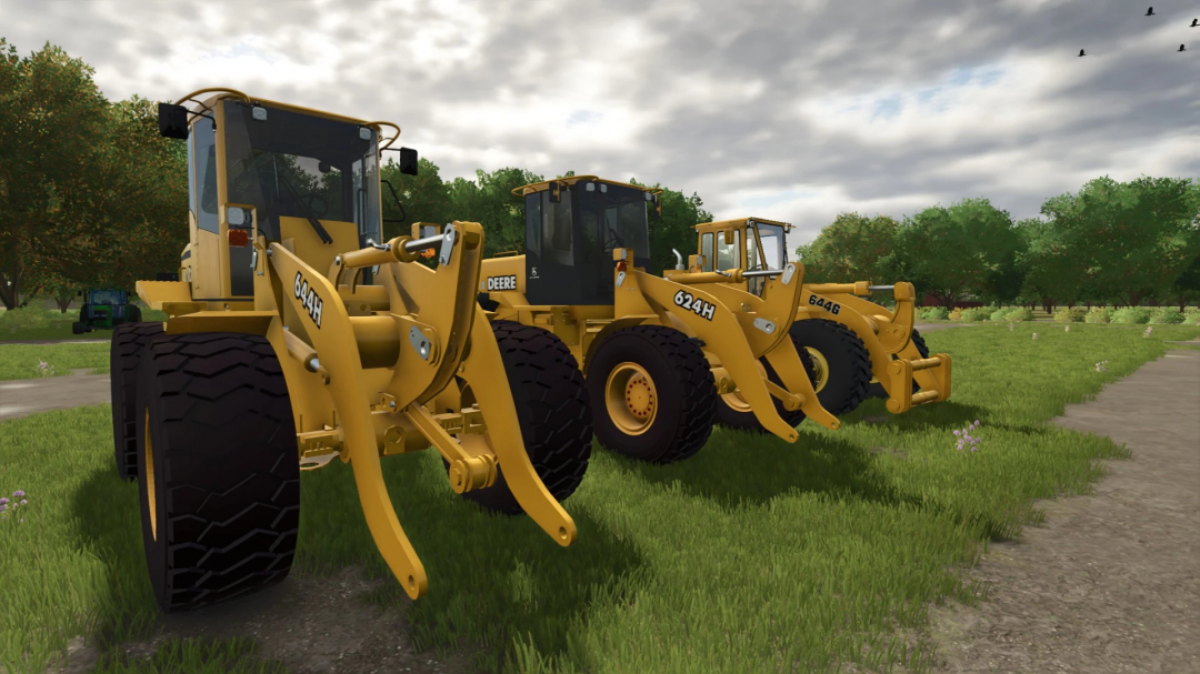 Three Deere wheel loaders from the FS25 mods pack parked on a grassy field in Farming Simulator 25.