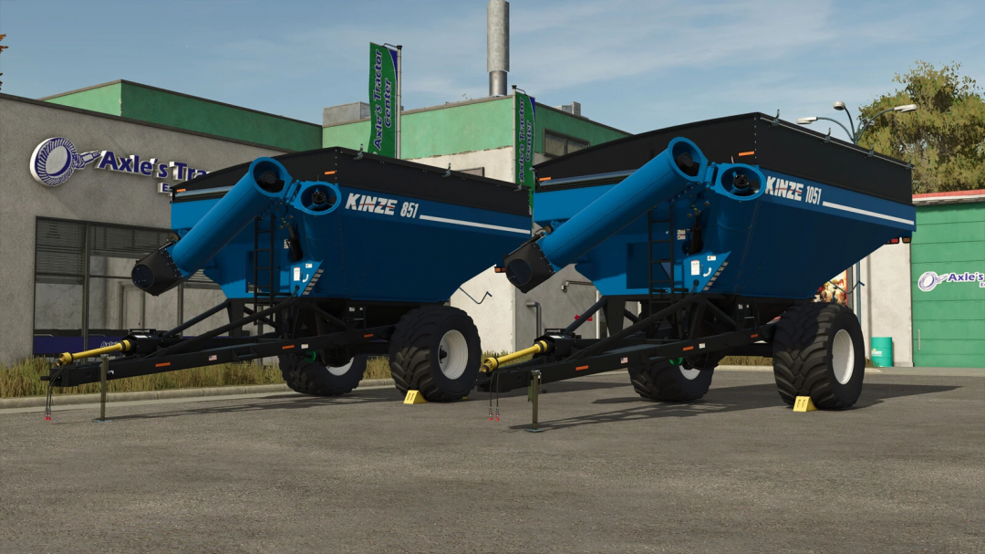 Two blue Kinze wagons, model 851 and 1051, lined up in front of Axle's Trailer Center in Farming Simulator 25, part of FS25 mods collection.