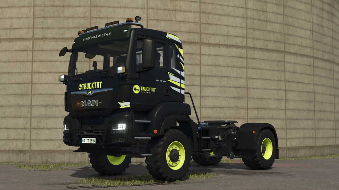 Farming Simulator 25 mod: MAN TGS 18 Series truck with black and yellow livery, featuring off-road tires, parked against a concrete wall.