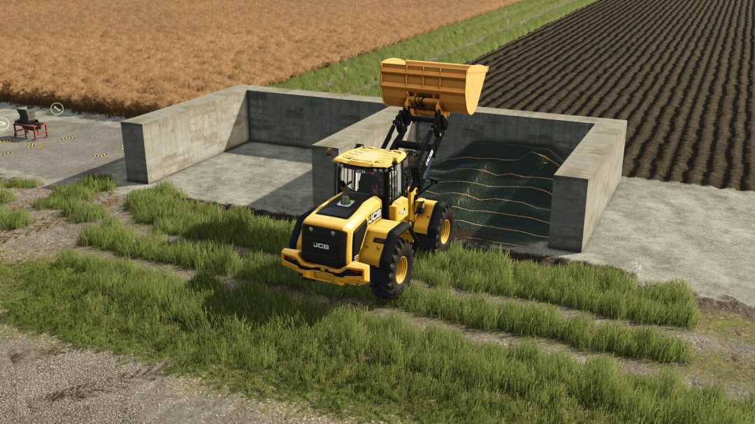 In Farming Simulator 25, a JCB loader is placing materials into a concrete compost bin as part of the Small Compost Production mod.