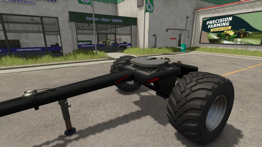 Farming Simulator 25 mod: Lizard Snüfelstück attachment with large tires and hydraulic arm, parked outside an Axle's Tractor Center.
