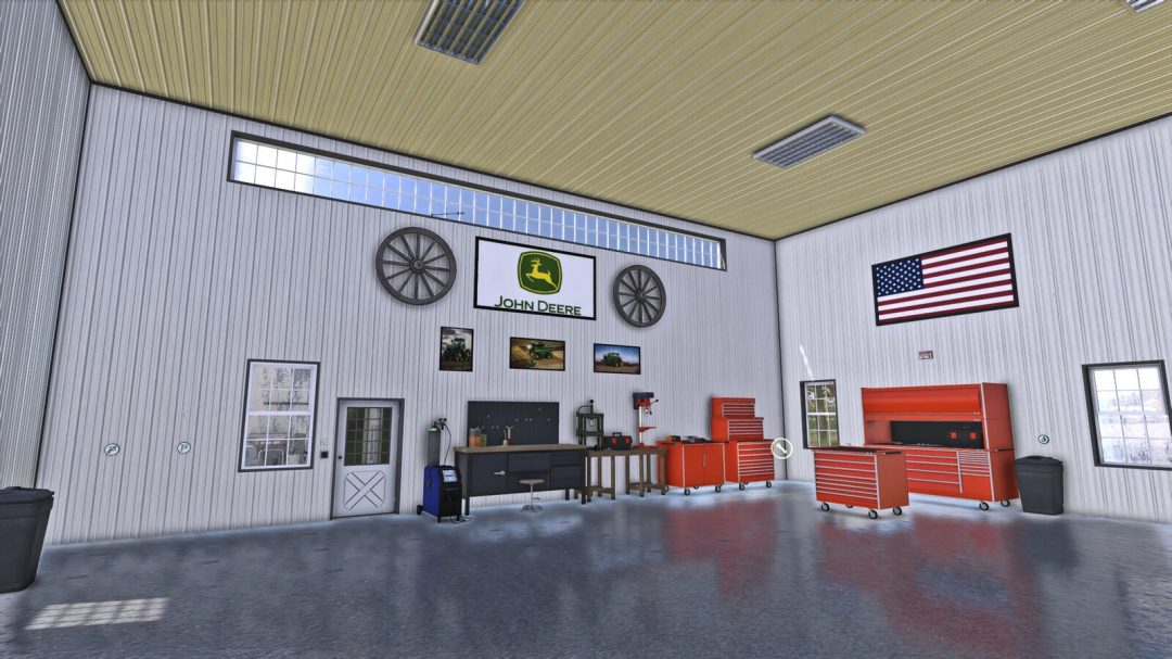 Inside a Farming Simulator 25 mod workshop featuring John Deere and American Midwest Shouse v1.0.0.0, with tools, toolboxes, and American flag.