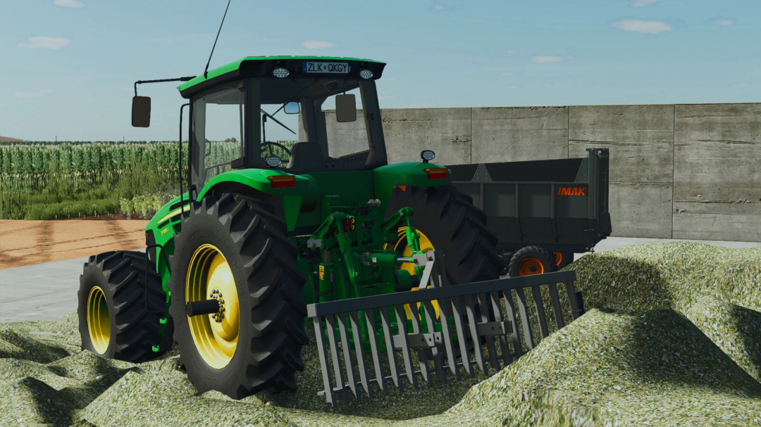 Farming Simulator 25 mod: Green tractor with IMAK GE 19270 trailer on a farm, featuring detailed attachments and crop field background.