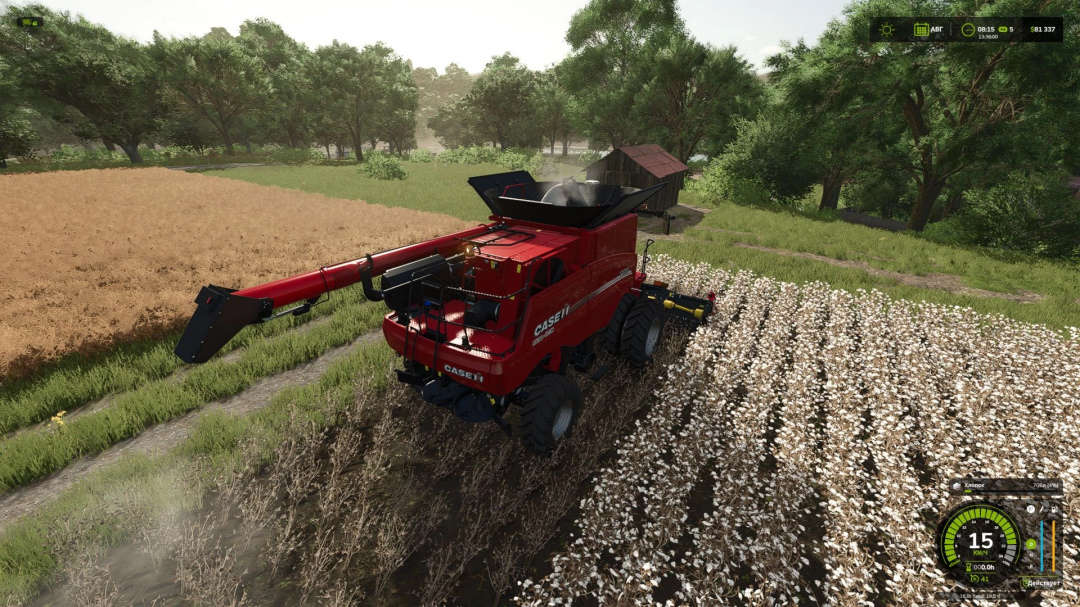 Farming Simulator 25 mod: Red cotton harvester working in a field with white cotton, surrounded by green trees and farm buildings.