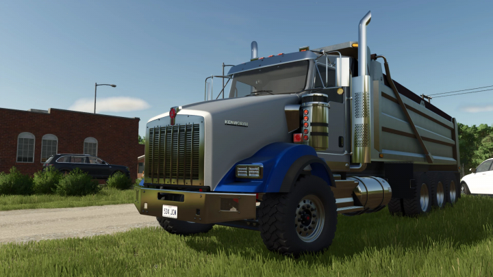 fs25-mods, Farming Simulator 25 mod: Kenworth T800 Dumper truck parked on grass with buildings and cars in the background.