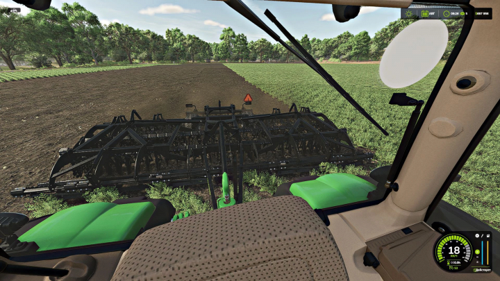 fs25-mods, View from inside a Farming Simulator 25 mod showing a green tractor cabin with a black tillage implement on plowed land, with trees in the background.