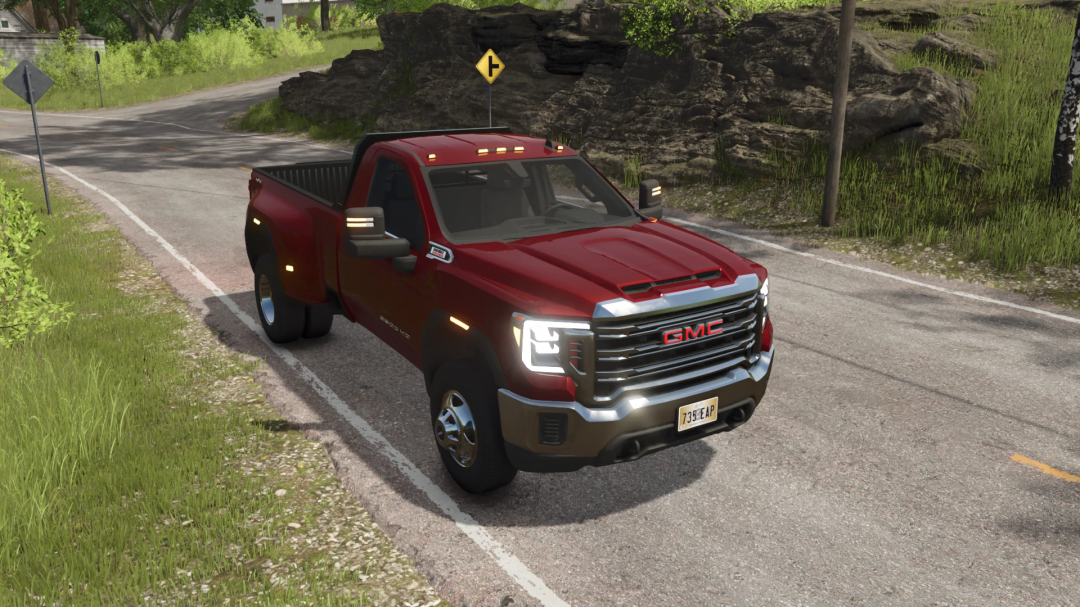 Red GMC Sierra 3500HD pickup truck mod in Farming Simulator 25, parked on a country road with green grass and rocks.