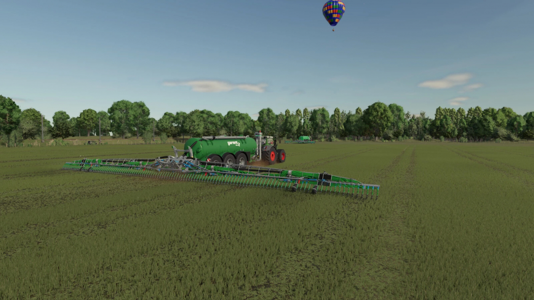 Farming Simulator 25 mod: a green Garant irrigation tanker attached to a tractor, watering a field with a hot air balloon in the sky.