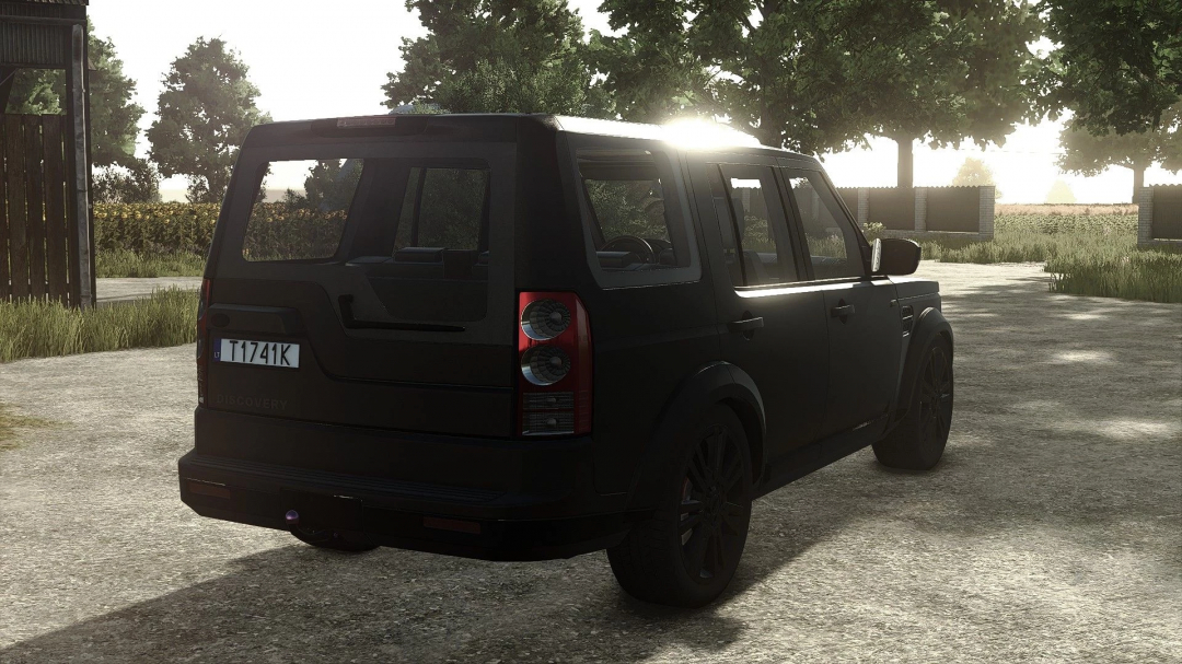 Black Land Rover Discovery 4 mod from Farming Simulator 25, parked on a gravel road with trees and sunlight in the background.