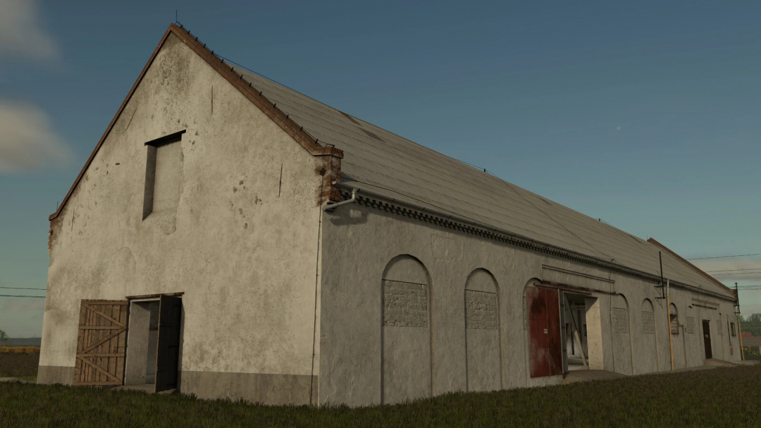 Old grain storage barn in Farming Simulator 25 mods, with weathered walls, open door, and a large sloped roof.