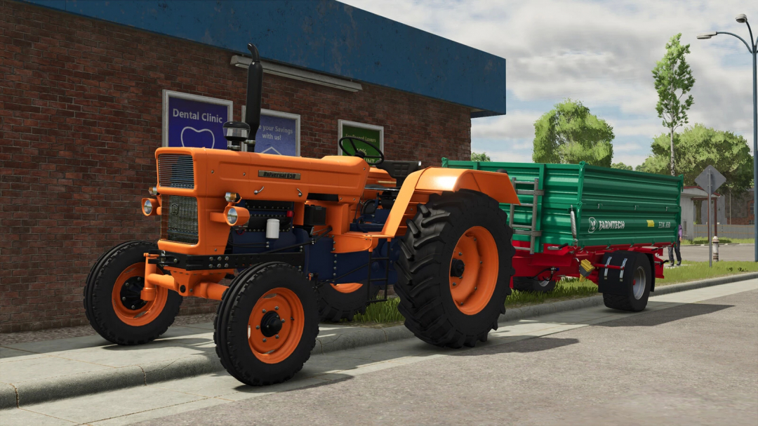 Farming Simulator 25 mod: Orange Universal 650 tractor with green Farmtech trailer parked on street.